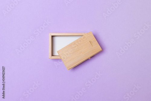 open wooden box with place for you logo on purple colored paper background