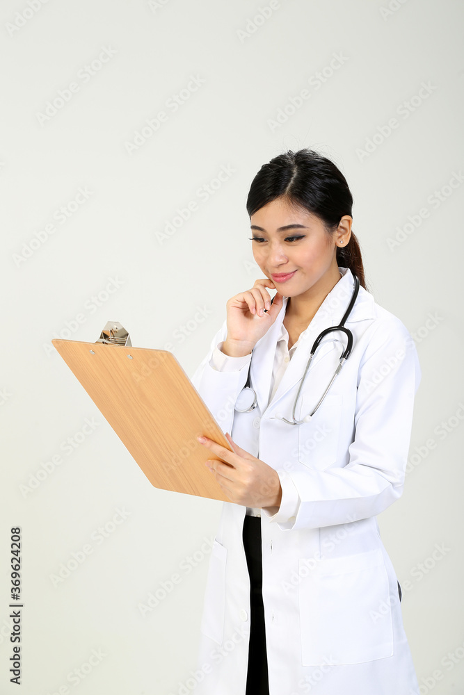 Young Asian female doctor wearing apron stethoscope holding writing on a clipboard Young Asian female doctor wearing apron stethoscope holding writing on a clipboard