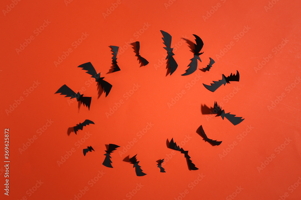 Flying bats on orange bright background. Halloween background. Top view. Flat lay Flying bats on orange bright background. Halloween background. Top view. Flat lay