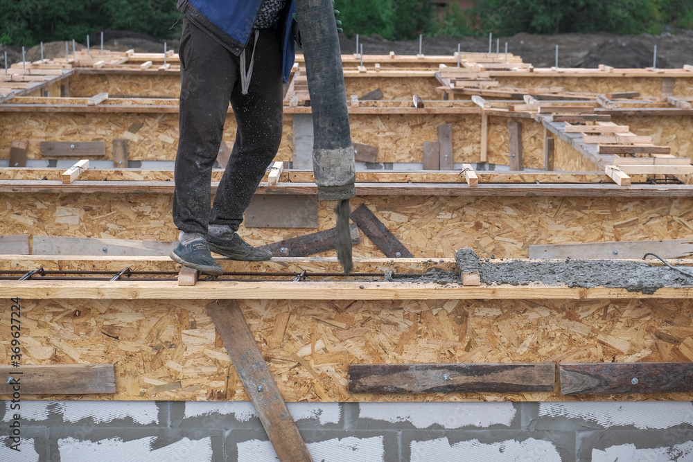 pouring concrete into the formwork at the construction site pouring concrete into the formwork at the construction site