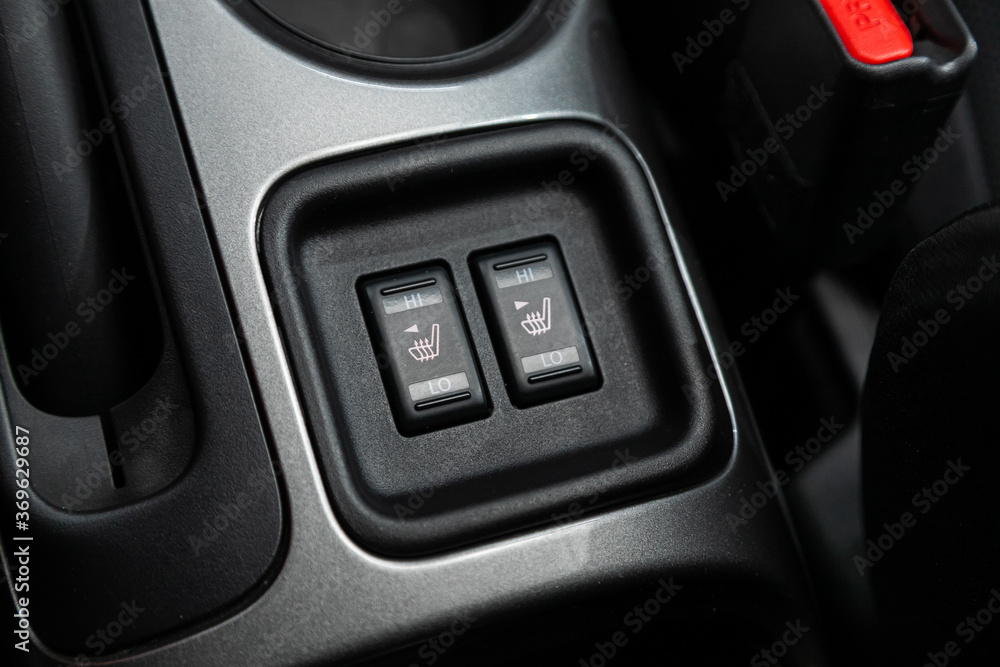close-up of black of seat heating buttons on car panel, no trade marks.
