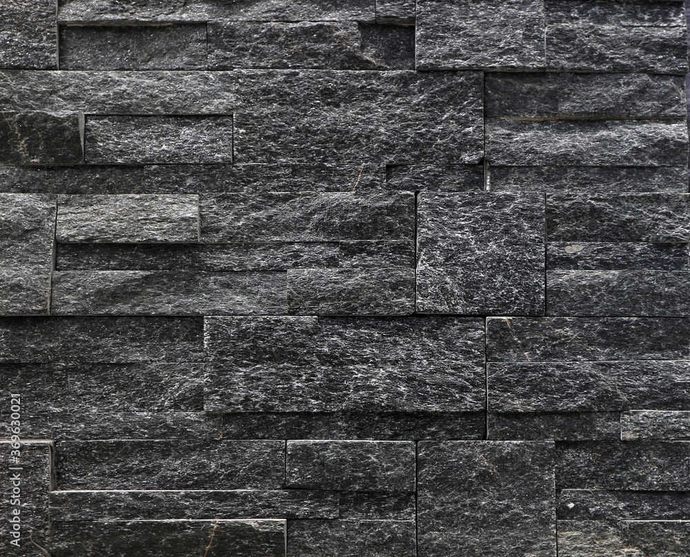 Black stone cladding wall made with different shape blocks. Background ...