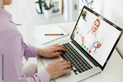 laptop with doctor on screen , online consultation