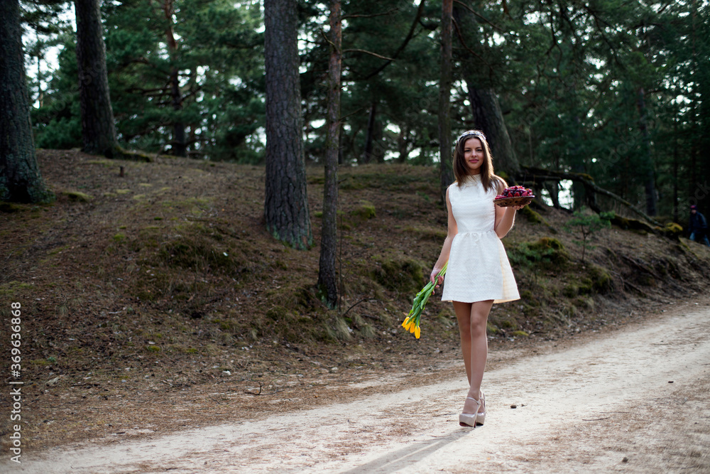 A girl in a white dress walks through the forest with fruits and flowers
A girl in a white dress walks through the forest with fruits and flowers