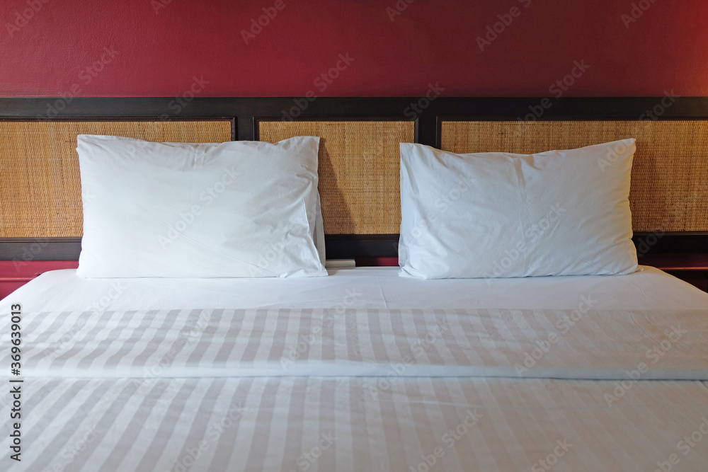 Front face view of a white bed set with red wall Front face view of a white bed set with red wall