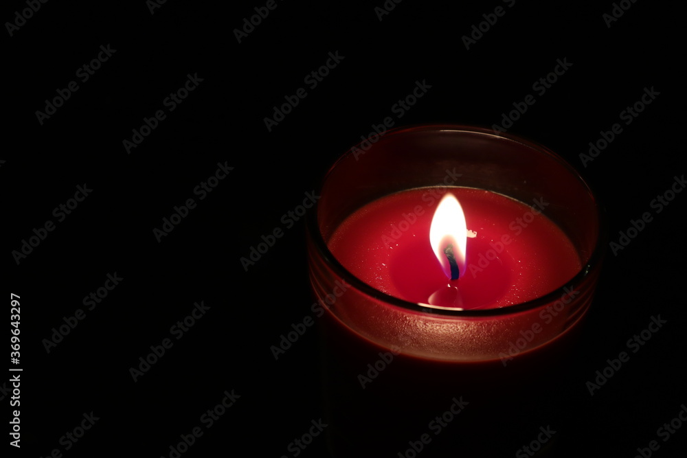 red candle on black background