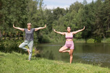 elderly woman doing in yoga and stretching with an instructor in nature. Healthy lifestyle concept. outdoor activities. 