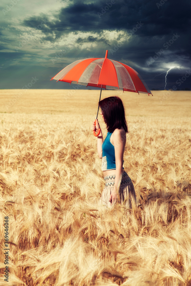 Young woman with umbrella in wheat field in rainy day Young woman with umbrella in wheat field in rainy day