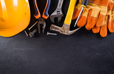 Happy Labor day concept. American flag with different construction tools on black table background.