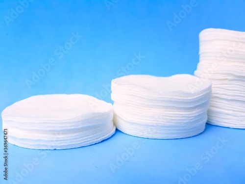 Round cotton discs on a bright blue background. Taking care of yourself.