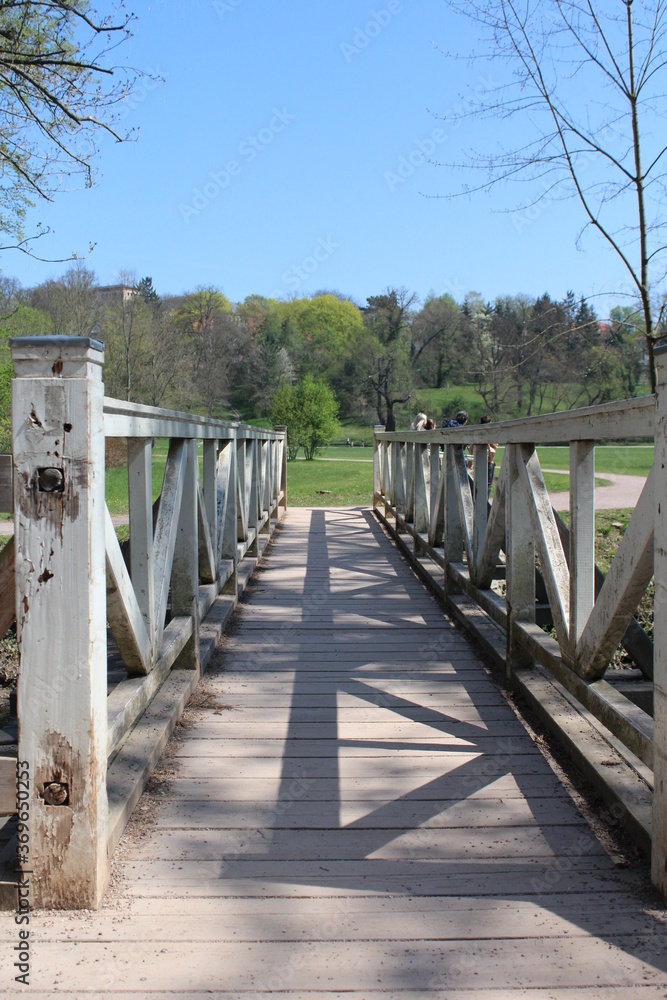 Obraz premium Wooden white bridge at a park during the summer in Weimar, Germany - Park an der Ilm