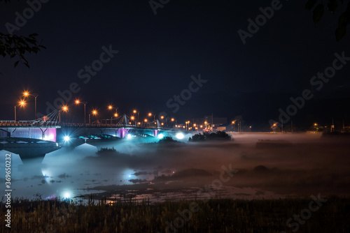 The beautiful dense foggy nightscape with bridge and lanterns light in the night. © Chongbum Thomas Park