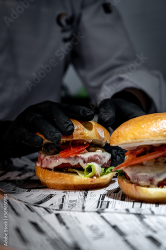 Manos de chef preparando sandwiches de hamburguesa