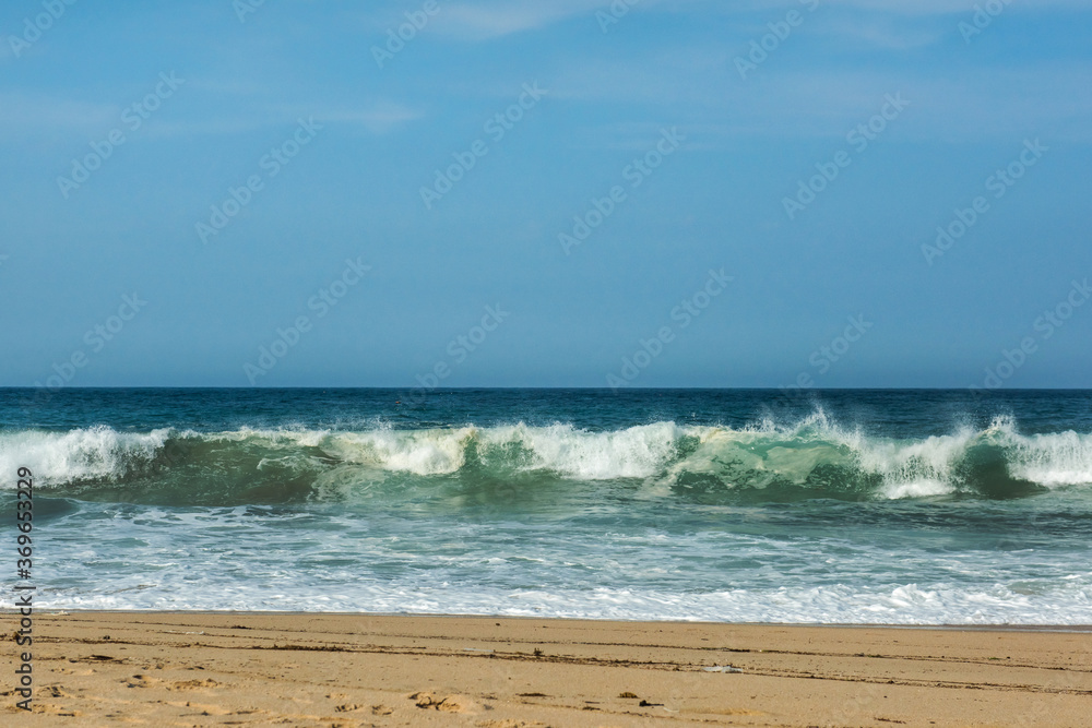 The big breaking waves during a strom at the beautiful summer sea shore background the blue sky and horizon The big breaking waves during a strom at the beautiful summer sea shore background the blue sky and horizon