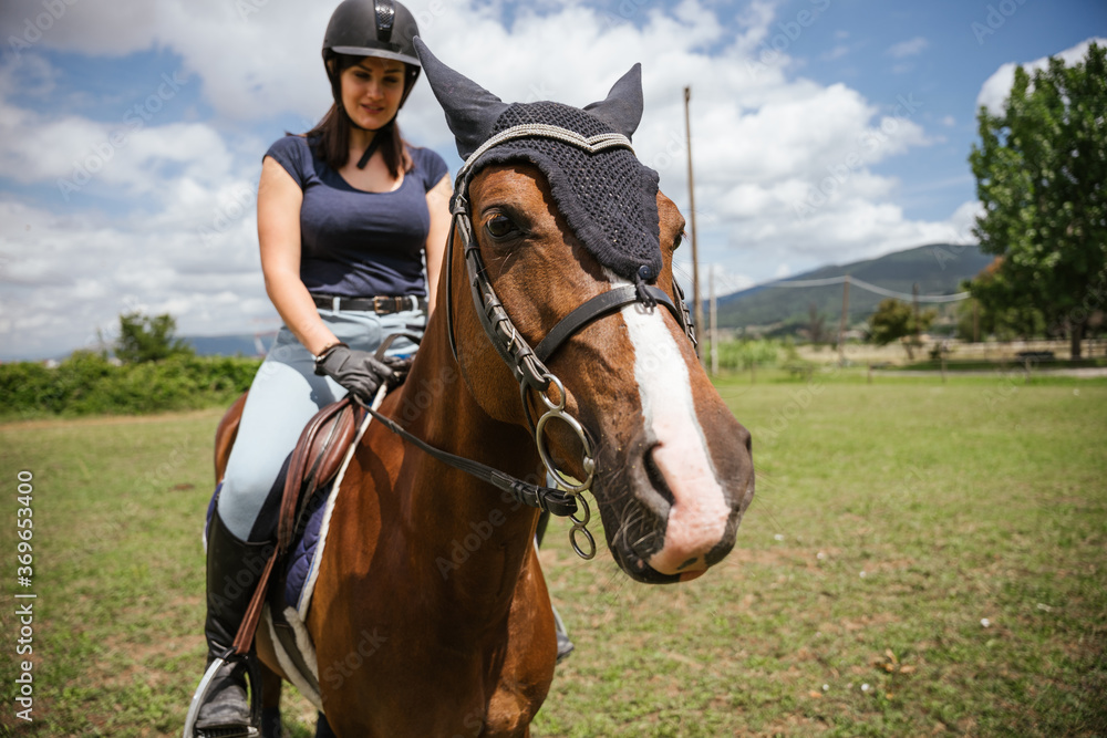 Beautiful young woman on a summer day rides with his horse in the grass field - Millennial has fun with his animal friend in a riding center Beautiful young woman on a summer day rides with his horse in the grass field - Millennial has fun with his animal friend in a riding center