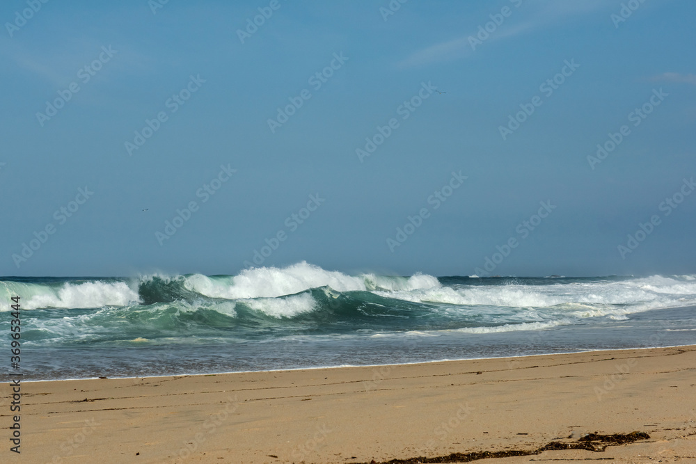 The big breaking waves during a strom at the beautiful summer sea shore background the blue sky and horizon The big breaking waves during a strom at the beautiful summer sea shore background the blue sky and horizon