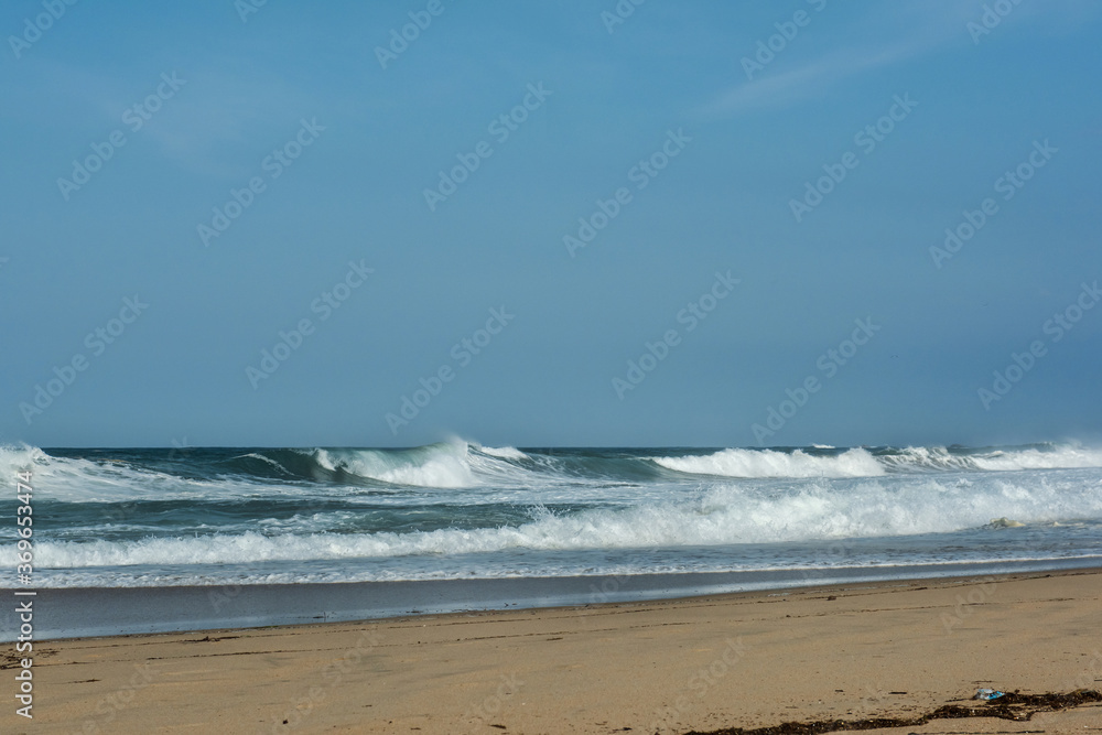 The big breaking waves during a strom at the beautiful summer sea shore background the blue sky and horizon The big breaking waves during a strom at the beautiful summer sea shore background the blue sky and horizon
