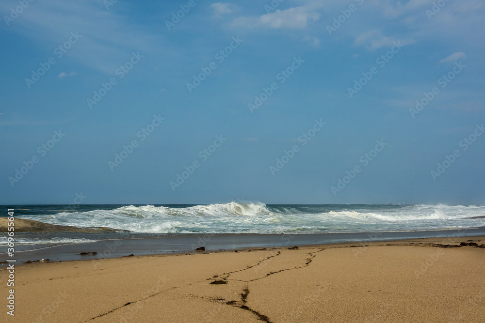 The huge waves crashing into ston island against the blue sky and horizon at summer sea shore. The huge waves crashing into ston island against the blue sky and horizon at summer sea shore.