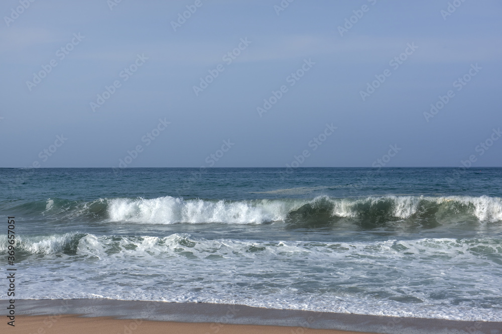 The huge waves crashing into ston island against the blue sky and horizon at summer sea shore. The huge waves crashing into ston island against the blue sky and horizon at summer sea shore.