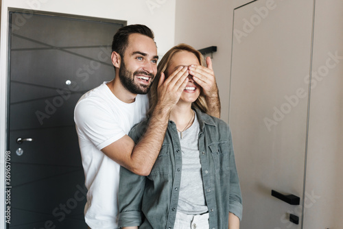 Man covering eyes of his girlfriend indoors at home