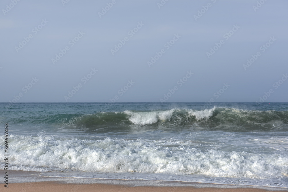 The huge waves crashing into ston island against the blue sky and horizon at summer sea shore. The huge waves crashing into ston island against the blue sky and horizon at summer sea shore.