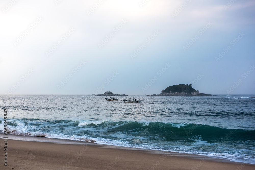 The huge waves crashing into ston island against the blue sky and horizon at summer sea shore. The huge waves crashing into ston island against the blue sky and horizon at summer sea shore.