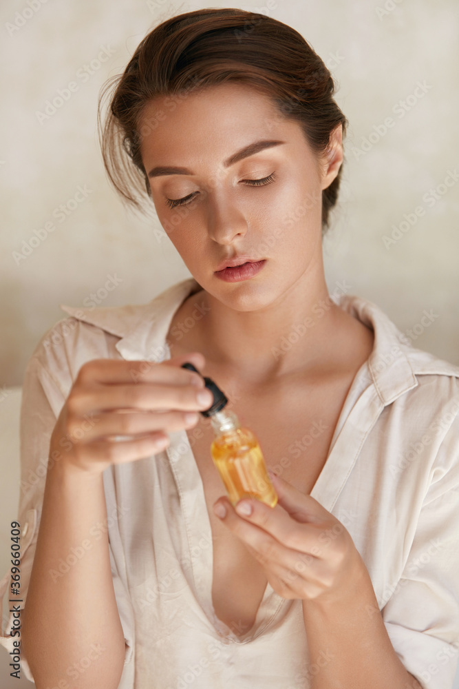 Woman With Bottle Of Essential Oil. Beauty Portrait Of Model Holding Natural Cosmetic Product. Organic Vitamin E, Serum Collagen And Hyaluronic Acid For Moisturizing Derma. Woman With Bottle Of Essential Oil. Beauty Portrait Of Model Holding Natural Cosmetic Product. Organic Vitamin E, Serum Collagen And Hyaluronic Acid For Moisturizing Derma.