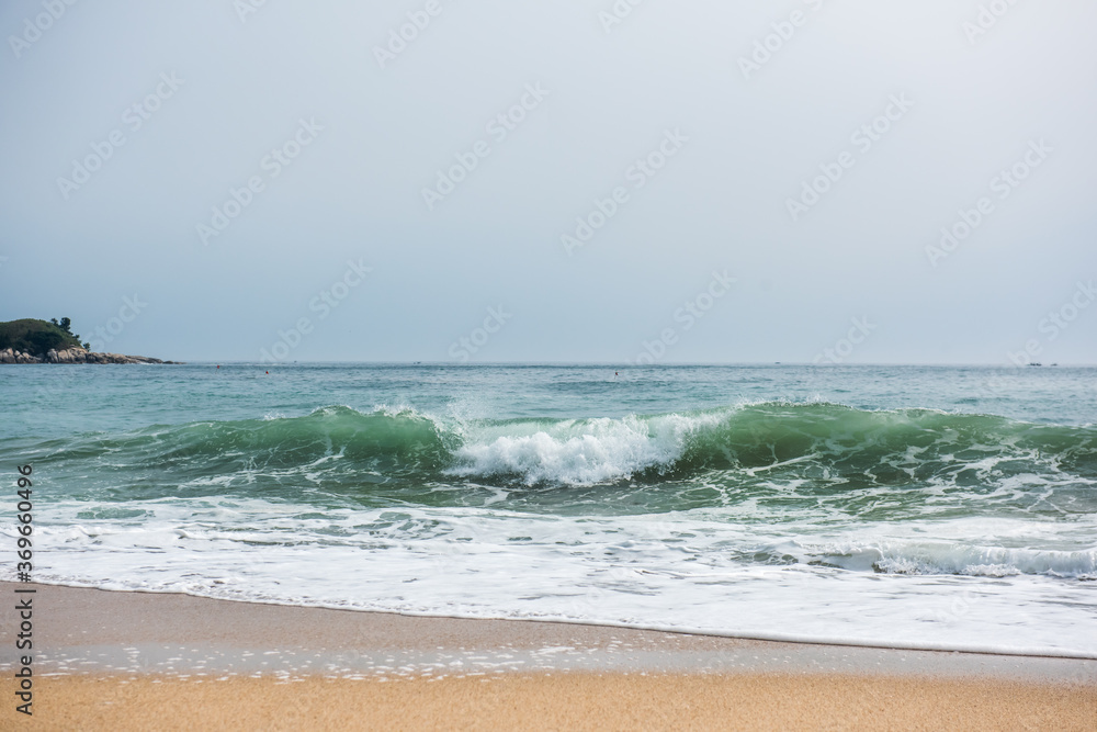 The huge waves crashing into ston island against the blue sky and horizon at summer sea shore. The huge waves crashing into ston island against the blue sky and horizon at summer sea shore.