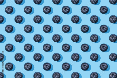 Fresh berries on blue background. Pattern of blueberries on blue background, top view