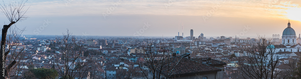 City 's skyline at sunset with the dome of Santa Maria Assunta Cathedral (Duomo Nuovo) standing out from the roofs conveys concept of human growth, society development and expansion - Brescia, Italy City 's skyline at sunset with the dome of Santa Maria Assunta Cathedral (Duomo Nuovo) standing out from the roofs conveys concept of human growth, society development and expansion - Brescia, Italy