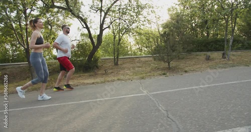Wallpaper Mural caucasian male with his personal coach young sporty female running outdoors in the morning. Healthy active lifestyle concept. Torontodigital.ca