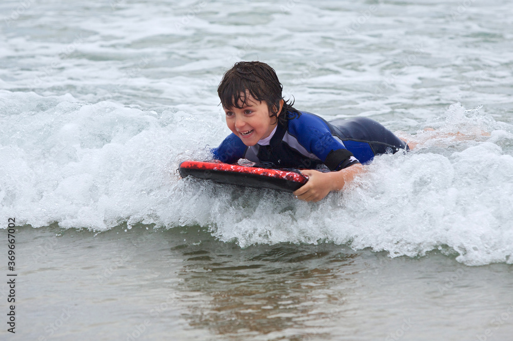 Child swimming with bodyboard on the sea waves. Child swimming with bodyboard on the sea waves.
