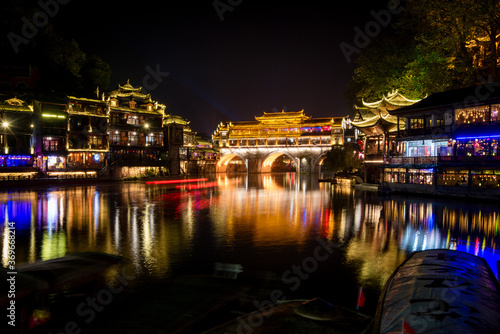 View of illuminated at night riverside houses in ancient town of Fenghuang known as Phoenix, China