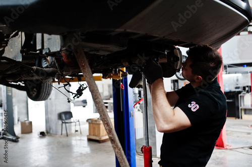Car repair and maintenance theme. Mechanic in uniform working in auto service. © AS Photo Family