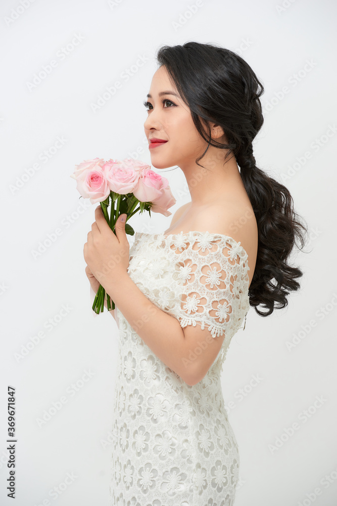 Beautiful young bride in wedding dress holding bouquet over white background. Copy space.