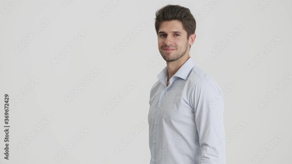 A smiling man is turning to the camera isolated over white background A smiling man is turning to the camera isolated over white background