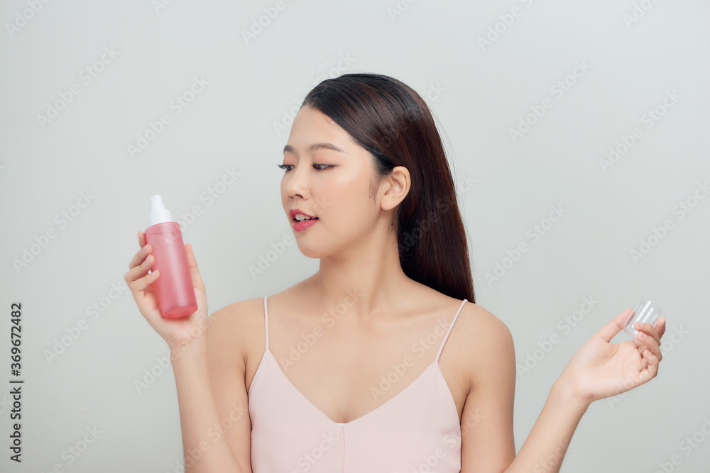 Beautiful woman applying spray water treatment on face Beautiful woman applying spray water treatment on face