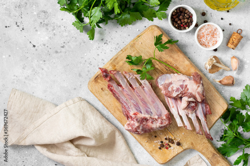 Lamb meat. Lamb ribs on a wooden chopping Board on the light gray kitchen table. Raw meat of a young lamb on the table. The view from the top 