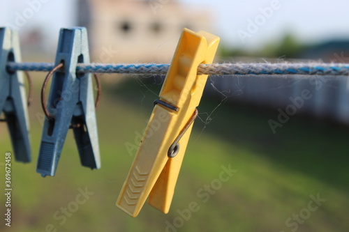 Macrophotography. Clothespins hang on a rope in the village. Yellow clothes pin
