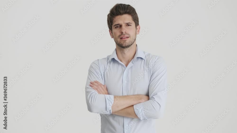 A serious man is holding his arms standing isolated over white background A serious man is holding his arms standing isolated over white background