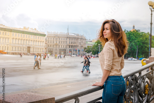A happy Young woman walks through the historic streets of Saint Petersburg in the center of the city in summer
