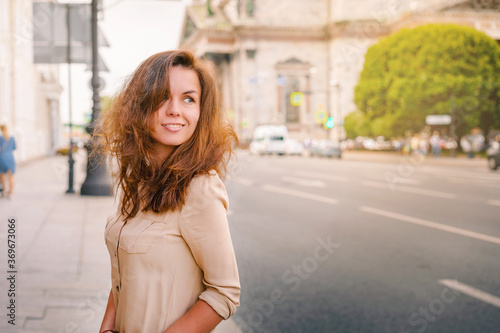 A happy Young woman walks through the historic streets of Saint Petersburg in the center of the city in summer