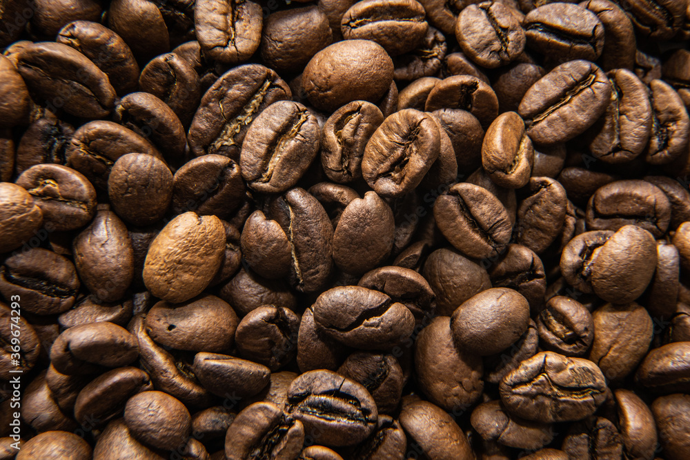 Naklejka premium many coffee beans lie together on the table