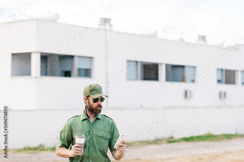 white man with security-watching beard controlling population areas and manufacturing