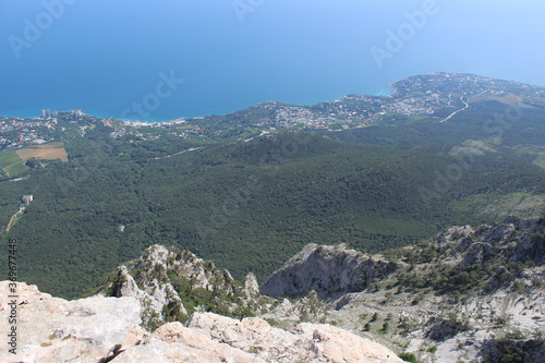 Beautiful sea landscape. Mountain flowing into the sea on the horizon. The views from the height of bird flight. View from the height of the mountain. Clouds over the sea. Beautiful rocks