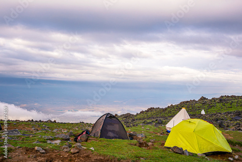 ase camp at  Ararat Mountain  approximate elevation  of 3300 meters with green pasture and rocks  is full of mountaineers in Agri  Turkey