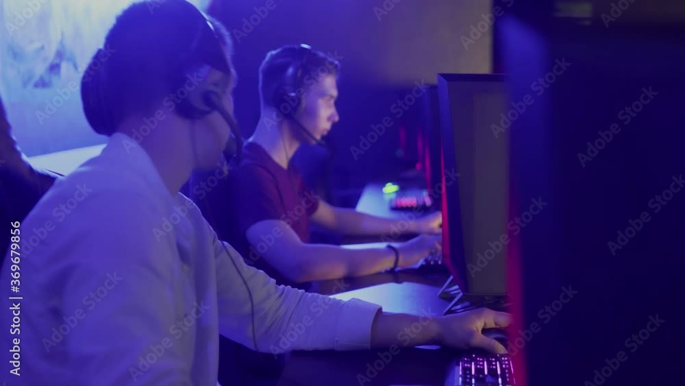 Two young friends plays an online game in a computer club. Two young friends plays an online game in a computer club.