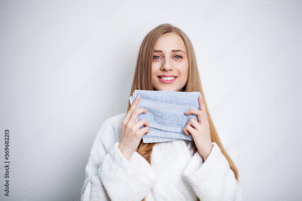 Young woman wiping her face with towel in bathroom. Young woman wiping her face with towel in bathroom.