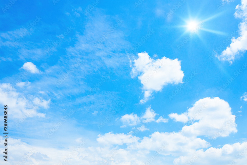 typical blue sky with sun and clouds background