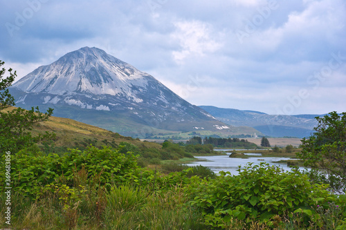 The white quartzite peak of Errigal, the highest mountain in Donegal, Ireland, towers over the bog and moor land of the Dunlewey valley.